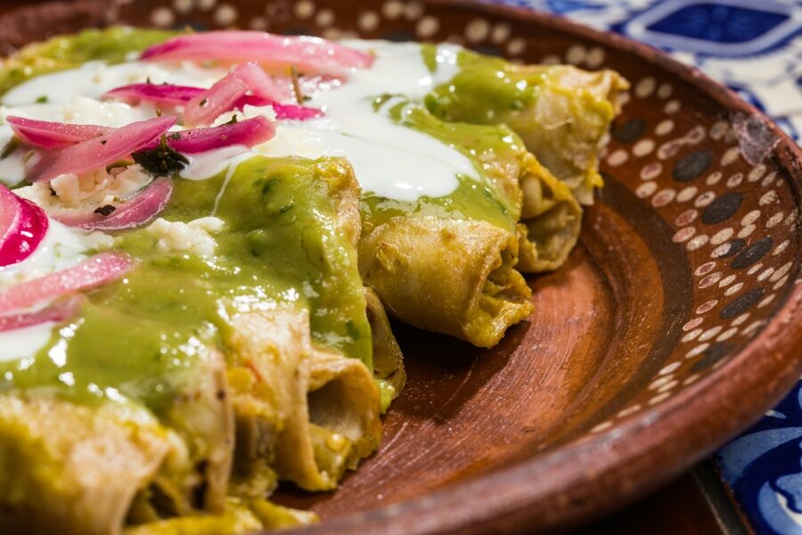 Enchiladas verdes con crema y cebolla morada en cazuela de barro tradicional