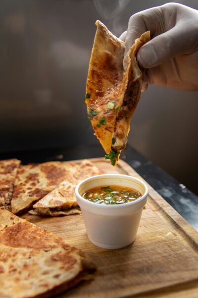 Quesataco crujiente de birria bañado en consomé caliente