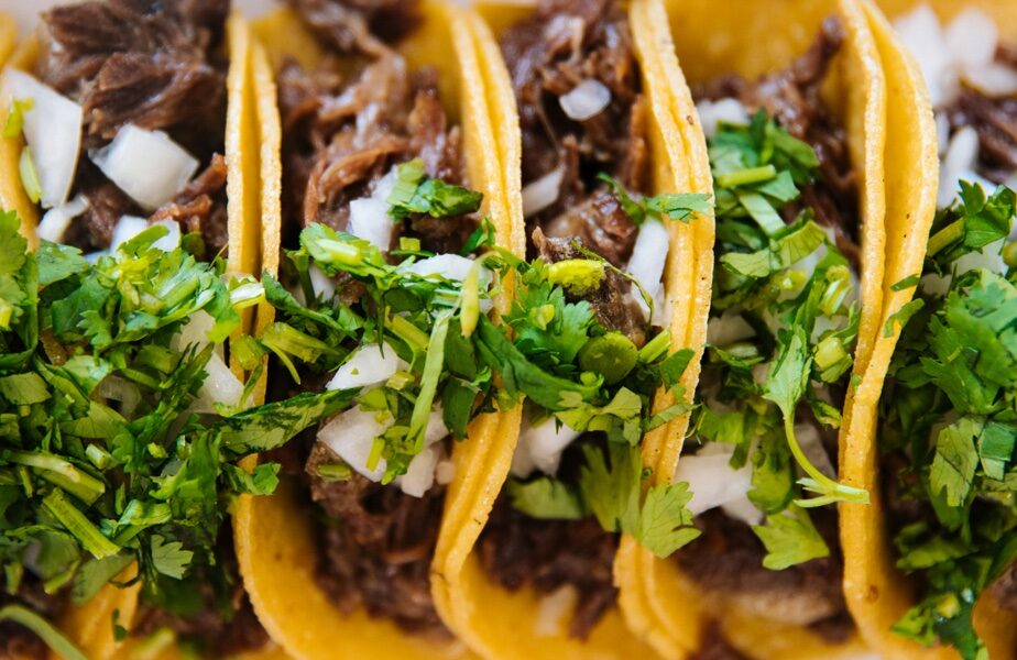 Trío de tacos callejeros con carne asada, cebolla picada y cilantro fresco